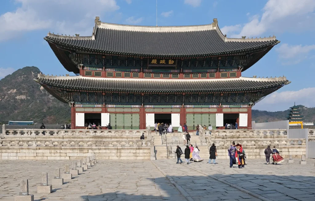 Geunjeongjeon hall at Gyeongbokgung, with visitors in the stone courtyard.