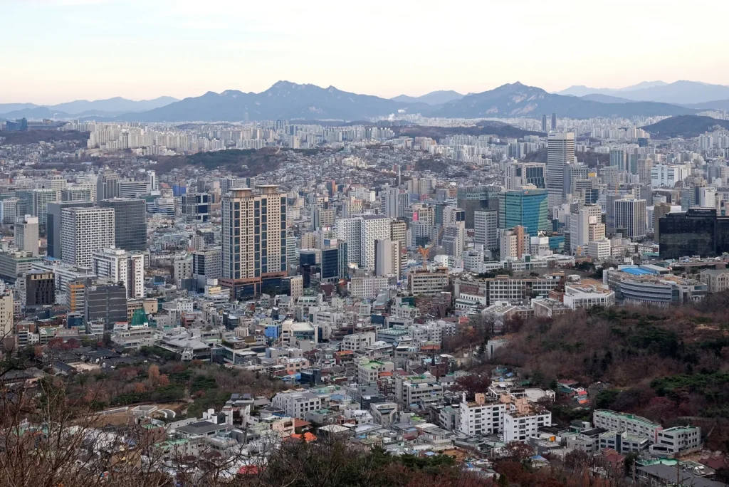 南山から見渡したソウルの建物と遠くの山々。