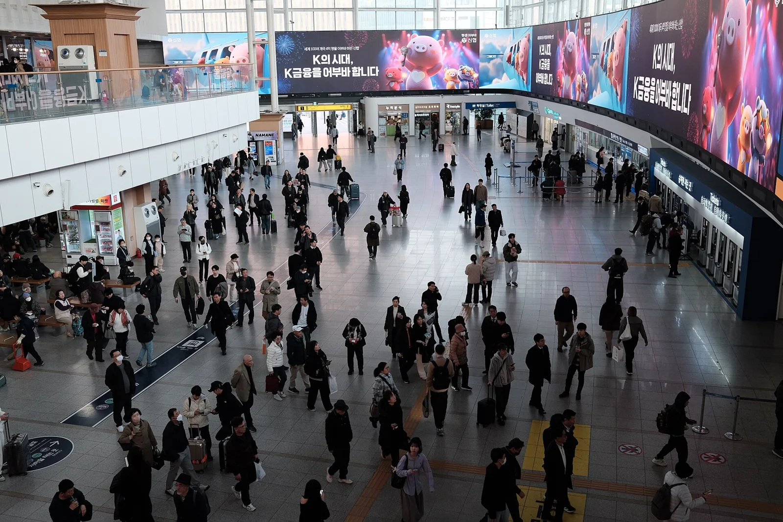 Passengers with luggage in the concourse at Seoul Station.